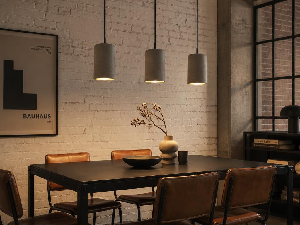 Loft industrial com pendente de concreto e mesa de ferro